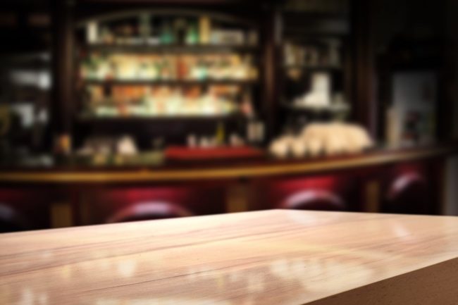 Verschwommenes Barbild mit Theke und Barhocker - Bargeld Wortwitz